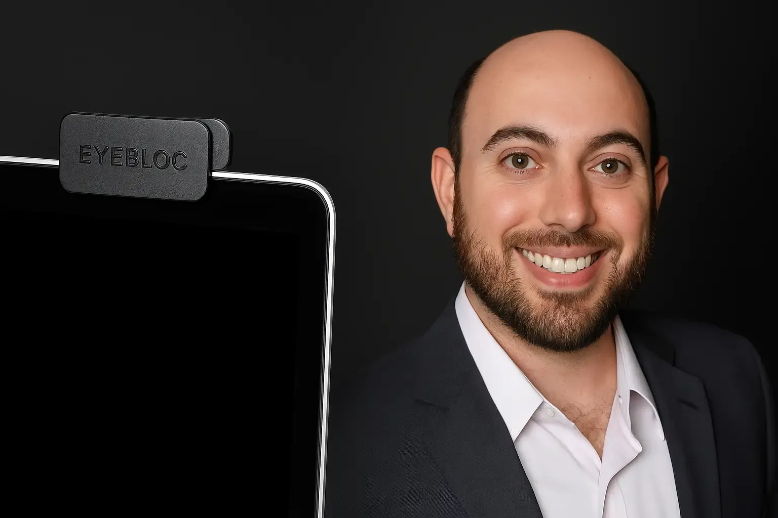 C.J. Isakow, founder of Eyebloc, beside a laptop showing the Eyebloc webcam cover in a professional product shot