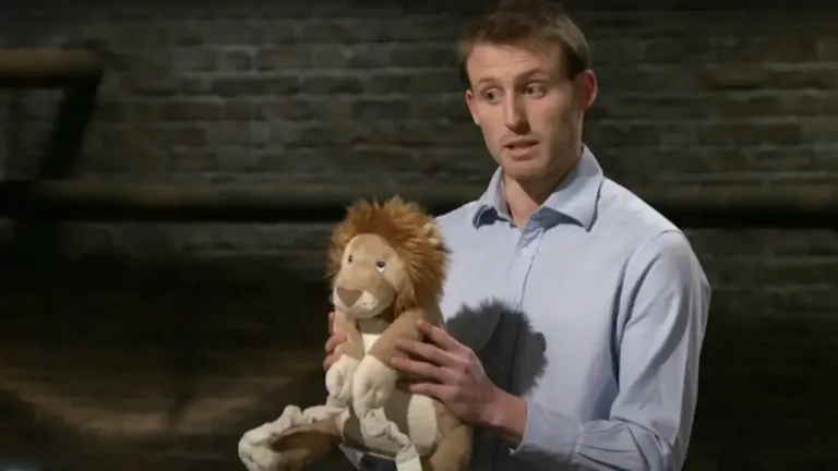James Roupell holding a Bobo Buddies lion plush during his Dragons' Den UK pitch for multifunctional children’s travel toys.