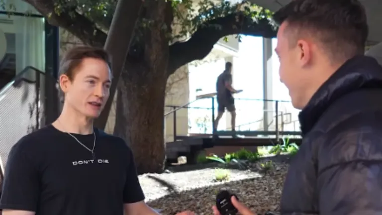 Bryan Johnson wearing a "DON’T DIE" shirt during a street interview about his anti-aging plan and the Rejuvenation Olympics.