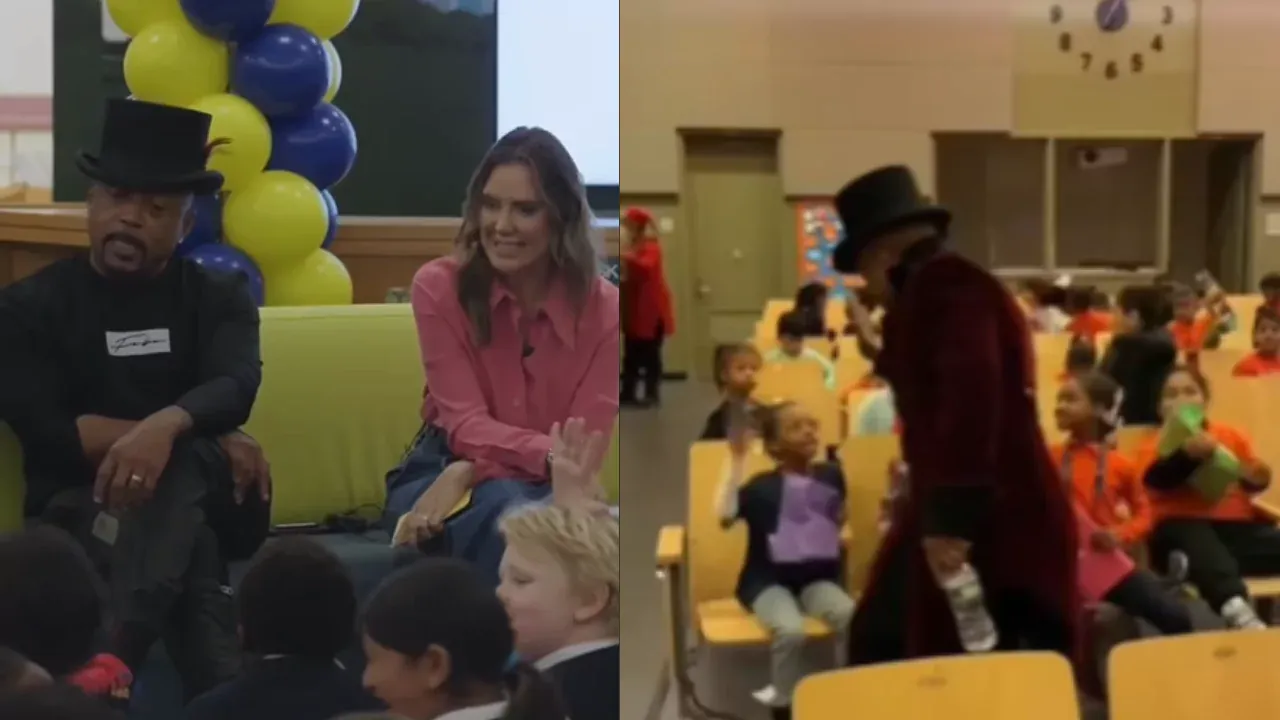 Daymond John wearing a top hat during a school visit, interacting with young students after being asked about his net worth.