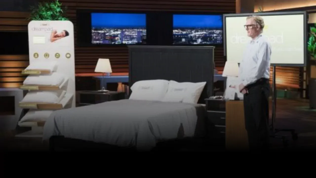 Dreampad founder presenting intrasound sleep pillow on Shark Tank with bed and product display in background
