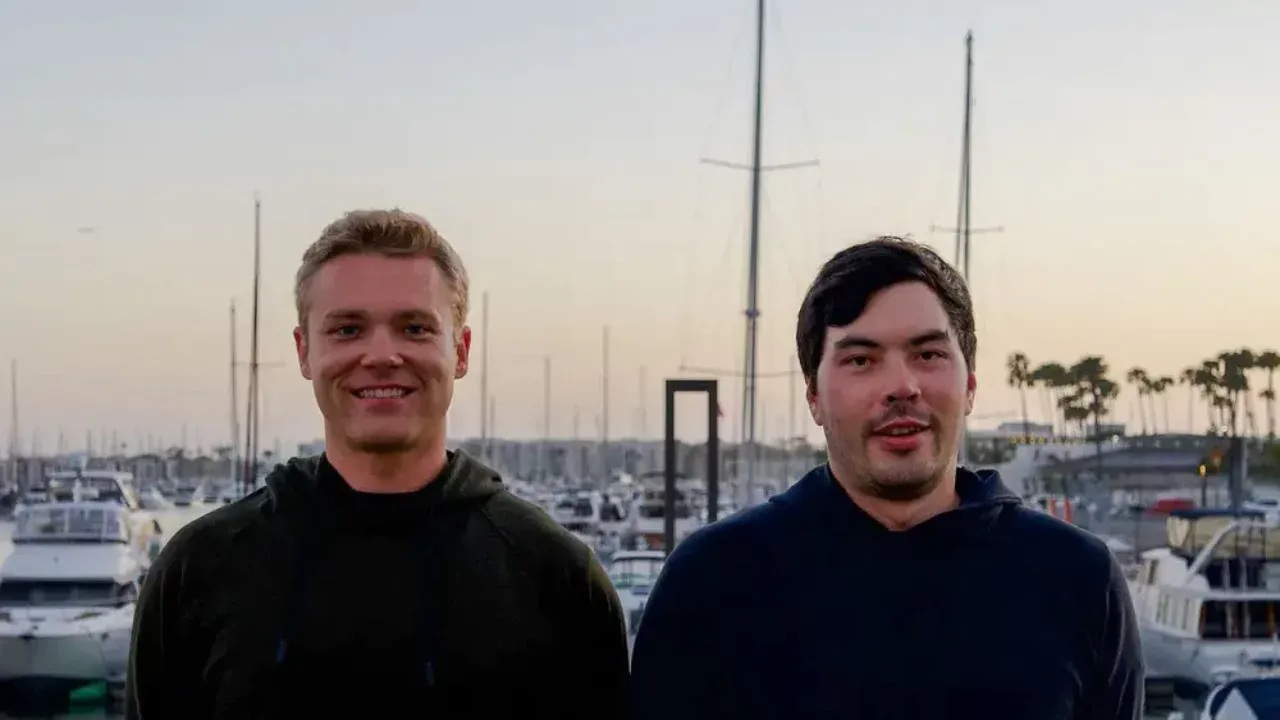 Two AndrenaM co-founders, including former SpaceX engineer Matej Cernosek, standing at a marina after raising $10M for their AI submarine detection startup.