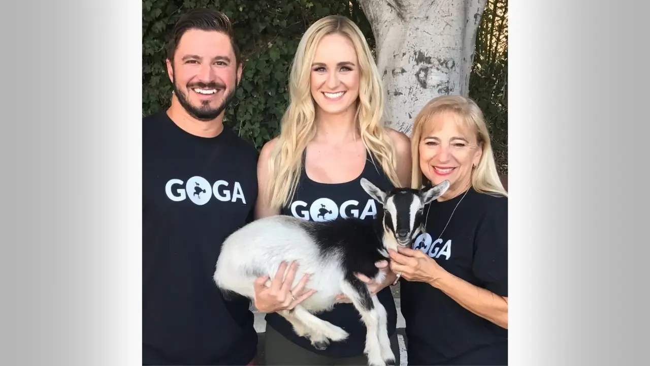 "GOGA Goat Yoga founders Rachael Phillips and Trey Kitchen holding a baby goat in Austin, Texas"