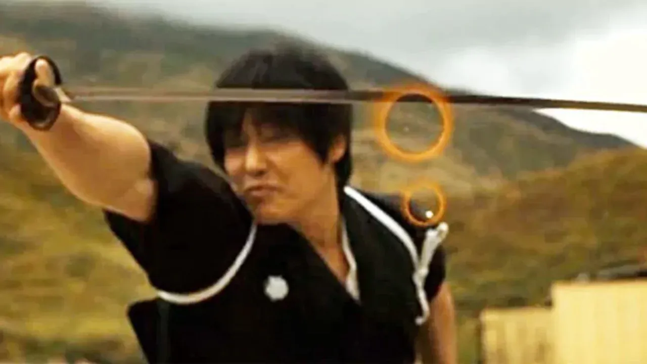 Isao Machii prepares to draw his katana in a dramatic low-light scene, demoIsao Machii prepares to draw his katana in a dramatic low-light scene, demonstrating his world-record sword techniquenstrating his world-record sword technique