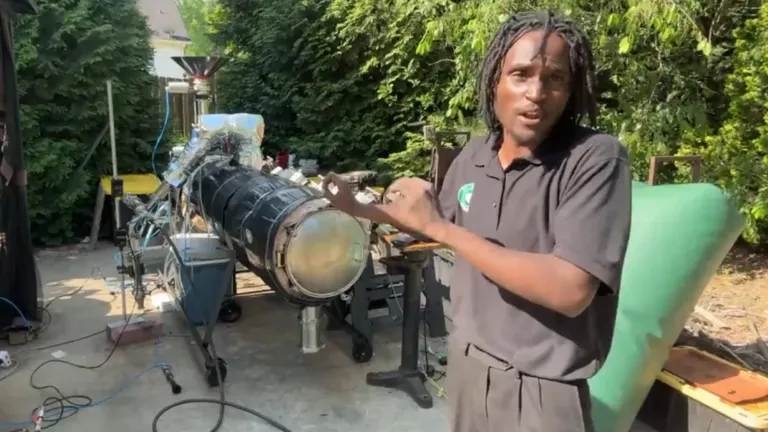 Julian Brown explains his Plastoline machine that converts plastic waste into usable fuel in his backyard workshop.