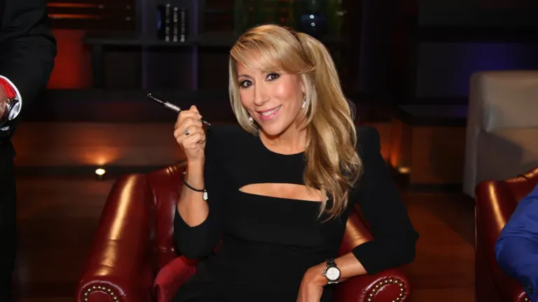Lori Greiner sitting in Shark Tank studio holding a pen, sharing tips to get products into major retail stores like Target and Walmart