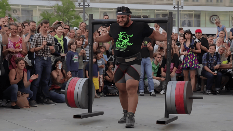 Patrik Baboumian performing a record-breaking 1,200-pound vegan strongman yoke carry during a public event