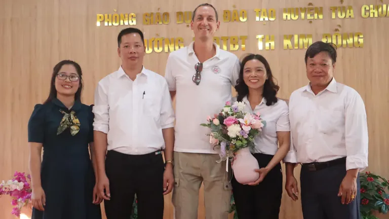 VFE Shark Tank Vietnam founder visits Kim Dong primary school with local educators holding flowers